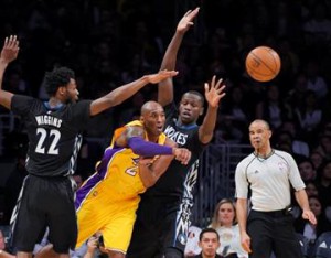 (AP Photo/Mark J. Terrill). Los Angeles Lakers forward Kobe Bryant, second from left, passes the ball as Minnesota Timberwolves guard Andrew Wiggins, left, and center Gorgui Dieng defend during the first half of an NBA basketball game Tuesday, Feb. 2, 2016.
