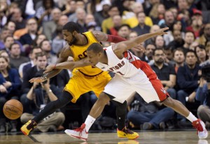 Toronto Raptors guard Kyle Lowry (7) battles for the ball against Cleveland Cavaliers guard Kyrie Irving, left, during first half NBA basketball action in Toronto on Friday, December 5, 2014. THE CANADIAN PRESS/Nathan Denette