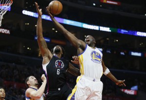 The Warriors’ Draymond Green (right) reaches for a rebound over Clippers center DeAndre Jordan and the Warriors’ Klay Thompson.