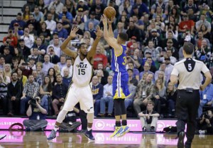 Golden State Warriors guard Stephen Curry (30) shoots as Utah Jazz forward Derrick Favors (15) defends during the second quarter of an NBA basketball game Wednesday, March 30, 2016, in Salt Lake City. (AP Photo/Rick Bowmer) 