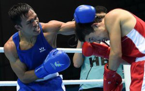 Charly Suarez (L) clashes in a bout against Uzbekistan’s Elnur Abduraimov (R) in the men’s light 60kg preliminaries session 2 at Seonhak gymnasium during the 2014 Asian Games in Incheon on September 24, 2014. (AFP PHOTO/ROSLAN RAHMAN) 