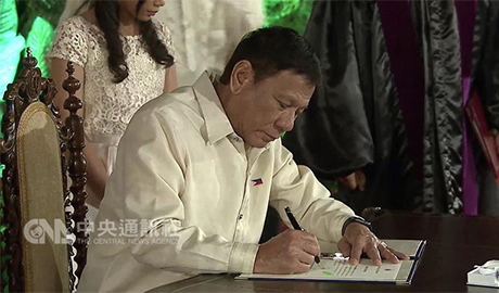 菲律宾总统当选人杜特地30日中午在马拉坎南宫黎萨厅 宣示就职，任期6年，成为菲律宾第16任总统。图为杜特地在宣誓後签署宣誓状。 