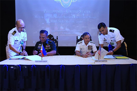 菲美两军22日在菲国三军总部完成年度相互防御理事会 暨安全接战理事会（MDB-SEB）会议。图为美军太平洋 司令部司令哈里斯（右二）与菲国参谋总长维萨亚（左二 ）在活动清单上签字。 