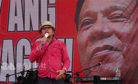 菲律宾21日在示威声中度过马可仕戒严第45周年，「挺杜」与「反杜」群众分庭抗礼，各自举办示威，表达诉求。图为挺杜特地总统的红衫军，在杜特地巨型海报前献唱。