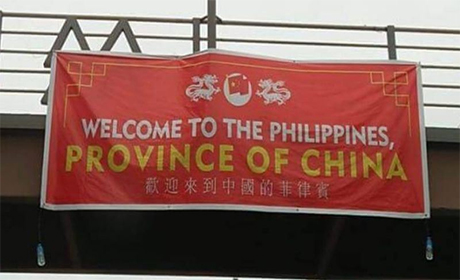 一条悬挂在人行天桥的红色横幅上写有英文字「WELCOME TO THE PHILIPPINES, PROVINCE OF CHINA」，英文字的下方则有中文字「欢迎来中国之省菲律宾」。