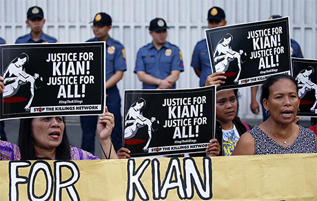 2017年8月23日，示威人士在菲律宾国家警察总部门外举牌丶呼口号，抗议警方杀害17岁高二学生基恩・桑托斯。