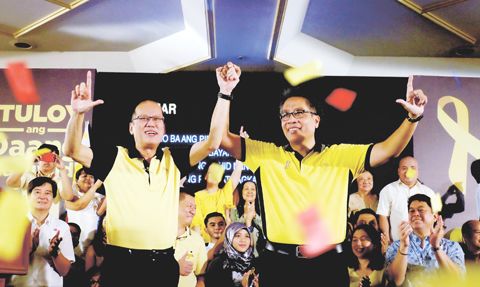 7月31日，菲律宾总统亚谨诺宣布提名菲当局内政部长罗哈斯代表执政的自由党竞选下届总统，罗哈斯随即宣布参选。图为亚谨诺（左）与罗哈斯（右）当天在自由党集会上牵手。